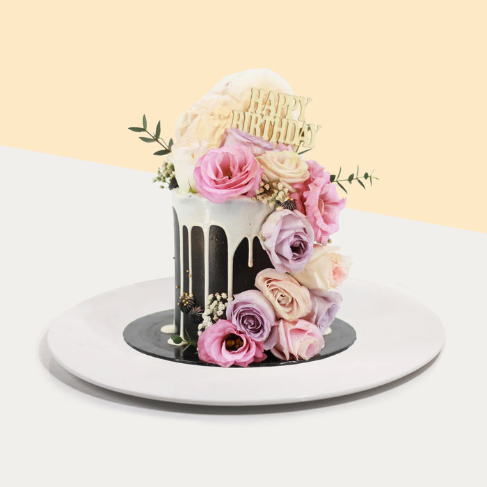 Black buttercream cake, glazed with white chocolate ganache, decorated with fresh flowers