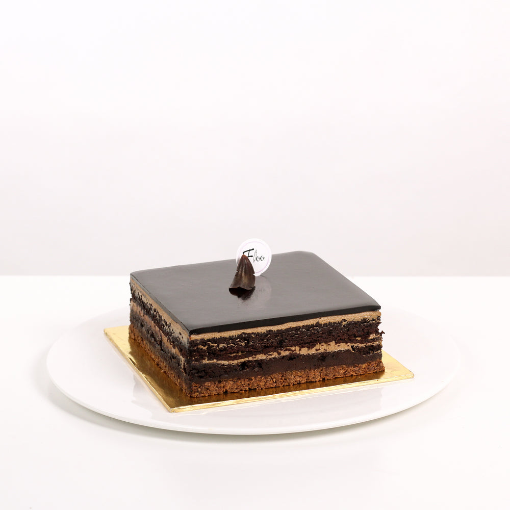 Square cuboid cake with a crunchy cookie base, moist chocolate cake, coffee buttercream and dark chocolate ganache