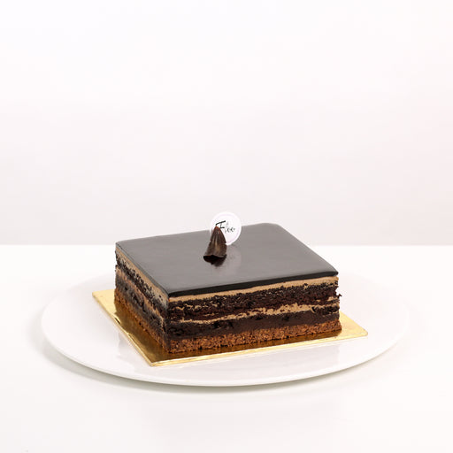 Square cuboid cake with a crunchy cookie base, moist chocolate cake, coffee buttercream and dark chocolate ganache