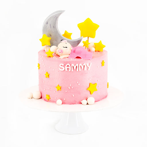 Pink buttercream cake with a sleeping baby