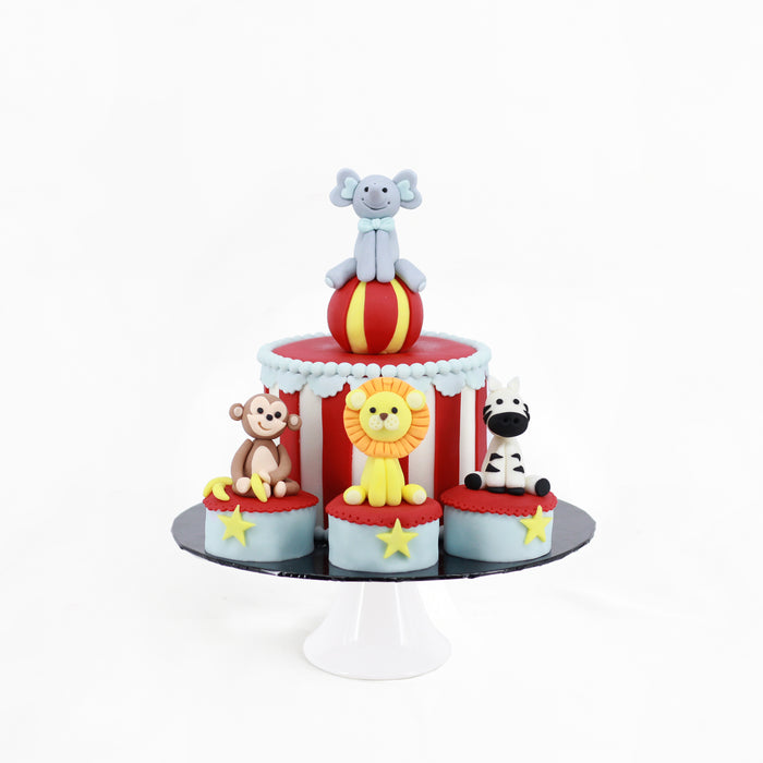 Circus themed cake decorated with fondant animals of elephant, monkey, lion and zebra
