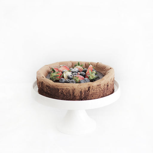 Flourless chocolate espresso cake, with a bed of fresh strawberries and blueberries