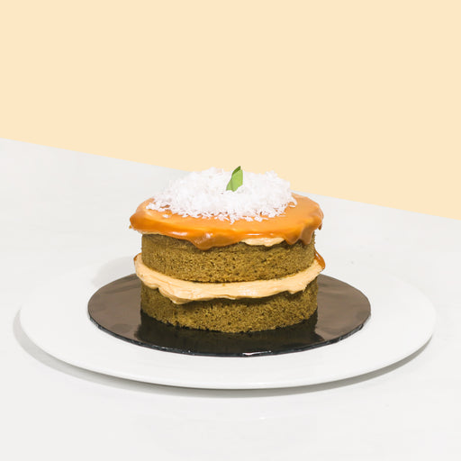 Mini green cake with Gula Melaka layers, topped with Gula Melaka glaze and coconut shavings