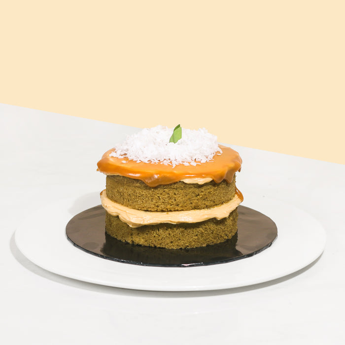 Mini green cake with Gula Melaka layers, topped with Gula Melaka glaze and coconut shavings