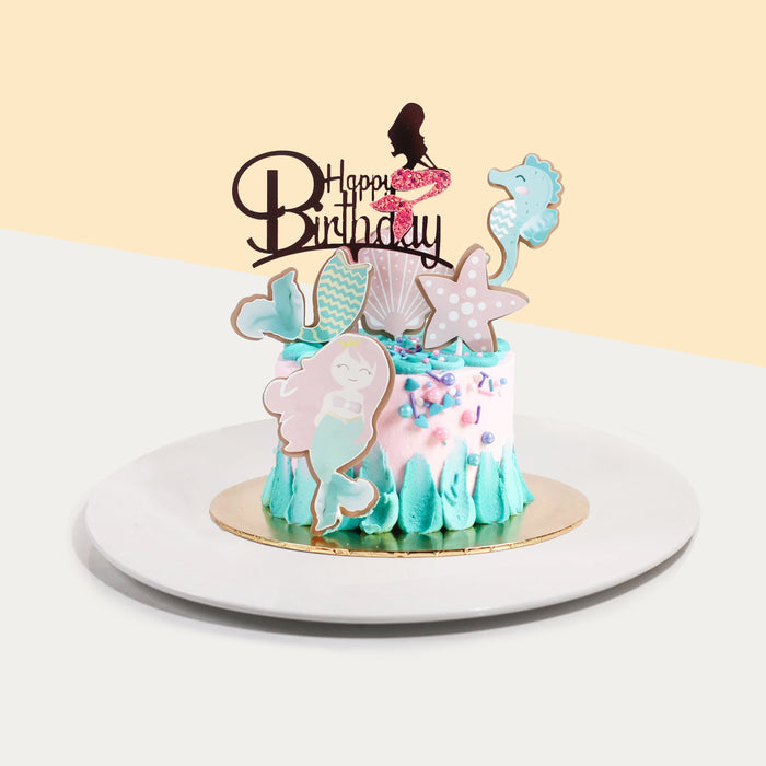 Cake decorated in blue and pink buttercream, decorated in mermaid theme