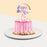 Pink buttercream frosted cake, with pink chocolate drizzle and a unicorn figurine on top