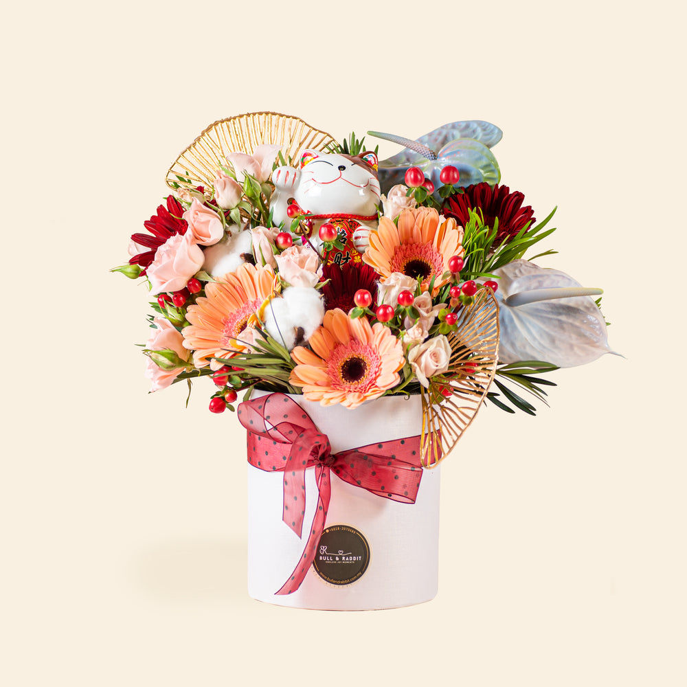 Flower box with bright orange, red and pink flowers, and a Lucky Fortune Cat