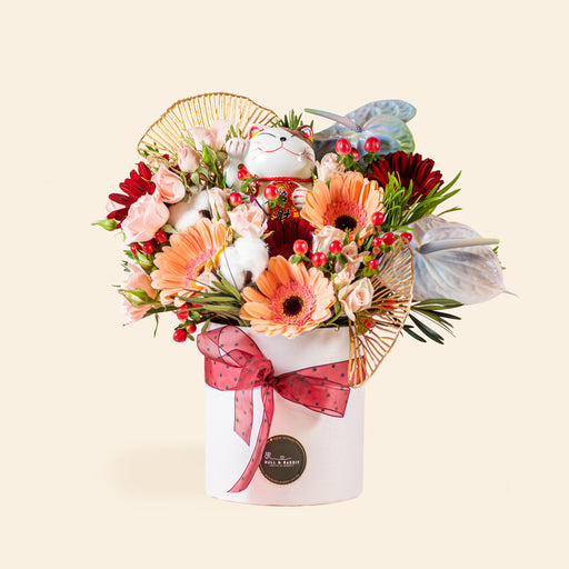 Flower box with bright orange, red and pink flowers, and a Lucky Fortune Cat