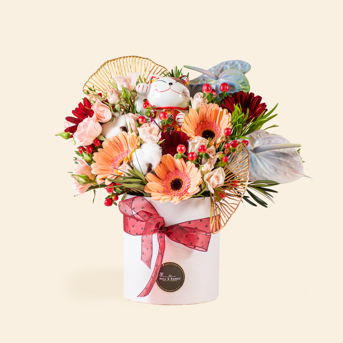 Flower box with bright orange, red and pink flowers, and a Lucky Fortune Cat