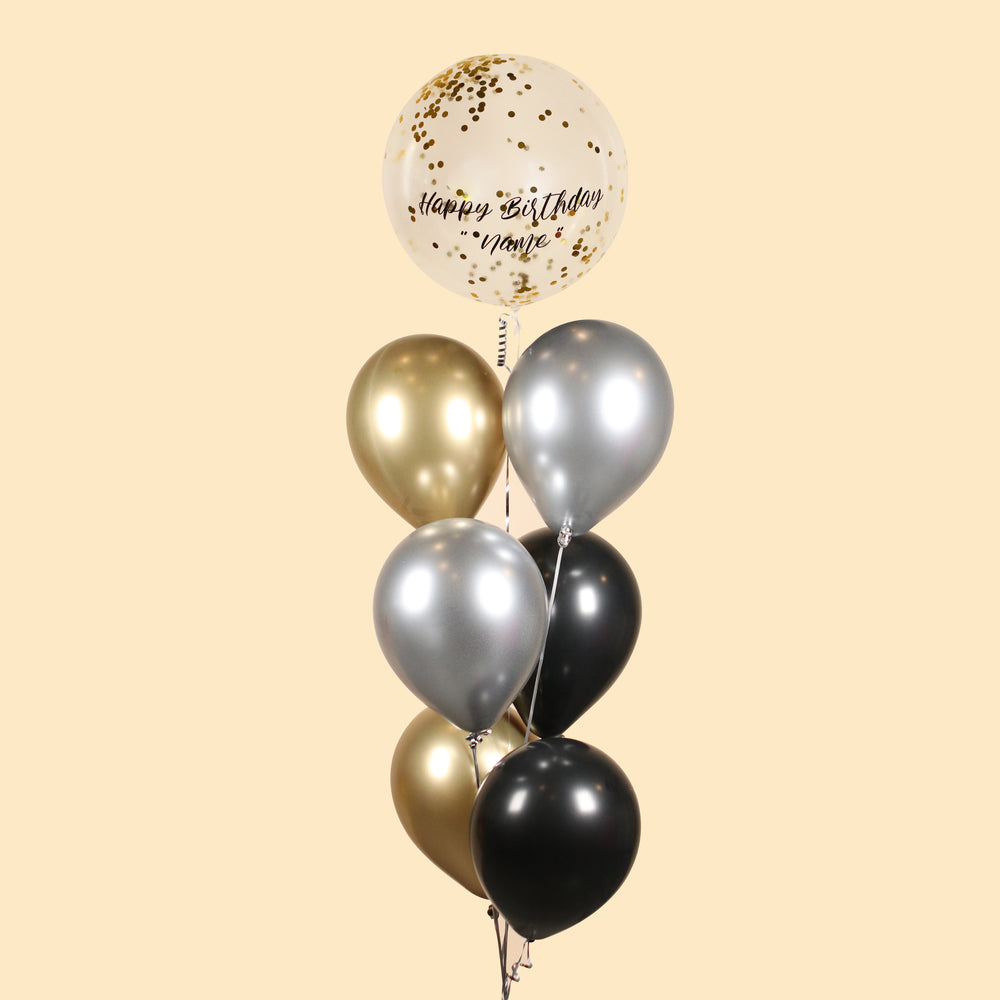 Gold confetti helium balloon with Happy Birthday, along with metallic gold, silver and black balloons