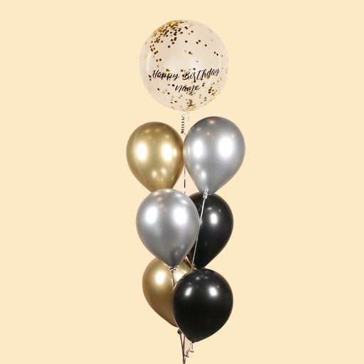 Gold confetti helium balloon with Happy Birthday, along with metallic gold, silver and black balloons