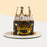 Black buttercream frosted cake with golden Happy Birthday topper, and a crown on top