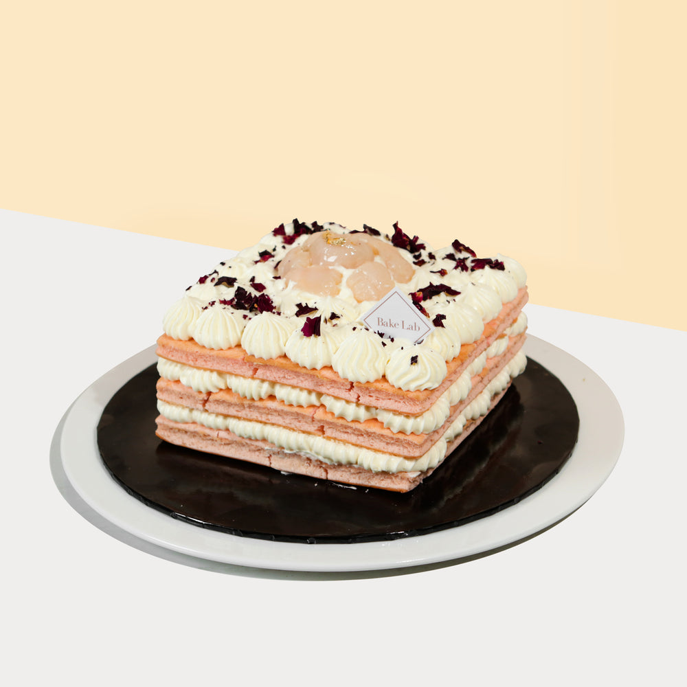 Pink genoise sponge cake coated in light rose buttercream and chunky lychee bits