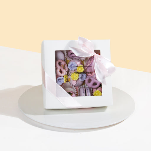 Giftbox with cakesicles, macarons, chocolate covered strawberries and mini pretzels