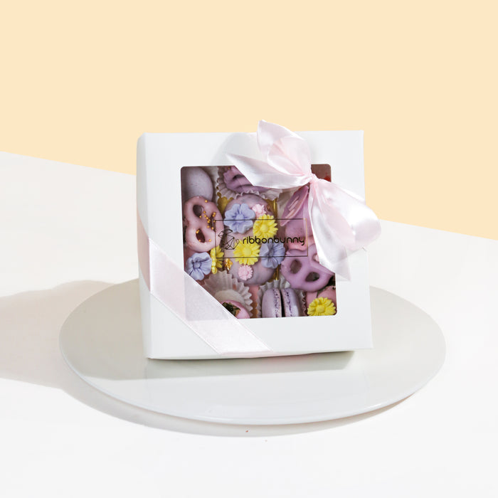 Giftbox with cakesicles, macarons, chocolate covered strawberries and mini pretzels