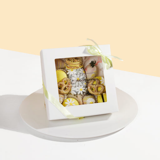 Giftbox with pretzels, macarons, cake pop and chocolate covered strawberries