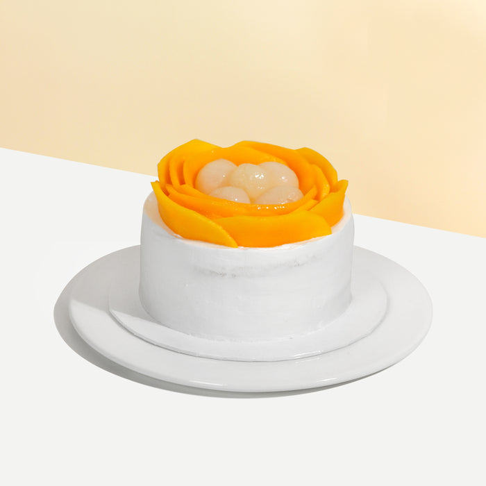 Sponge cake frosted in fresh cream, topped with mango slices and longans