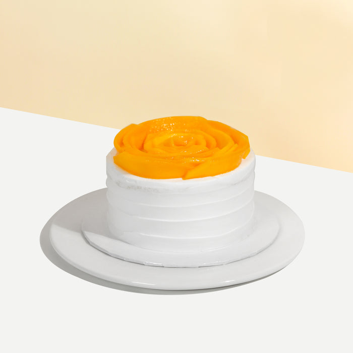 Sponge cake with cream cheese frosting, topped with mango slices