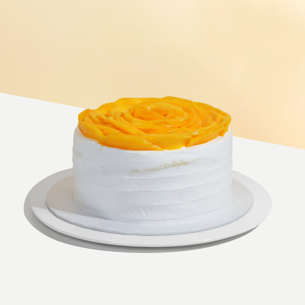 Sponge cake with cream cheese frosting, topped with mango slices