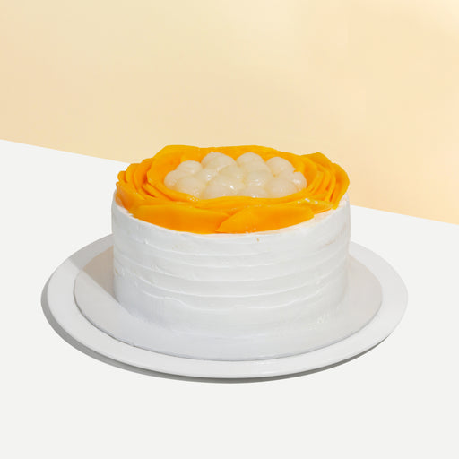 Sponge cake frosted in fresh cream, topped with mango slices and longans