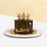Black buttercream cake, with a golden crown and decorations