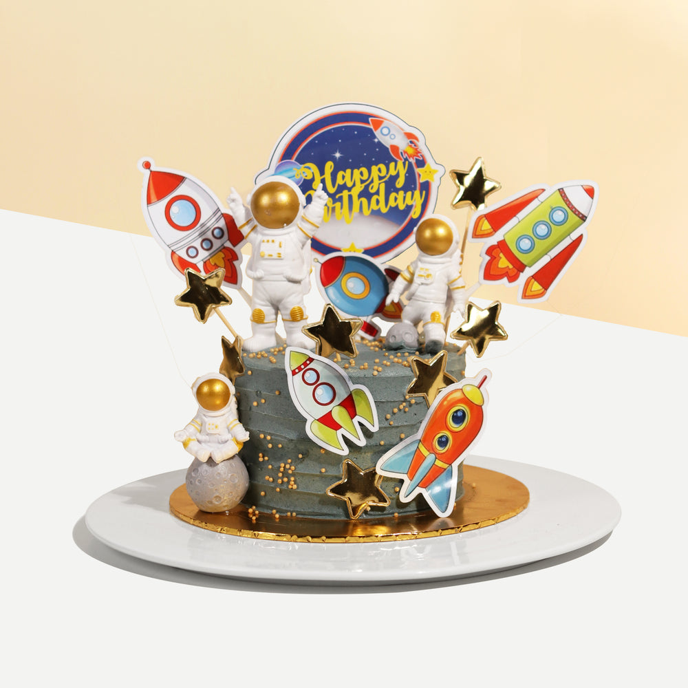 Grey buttercream frosting cake, with 2d printed rockets and astronaut figurines
