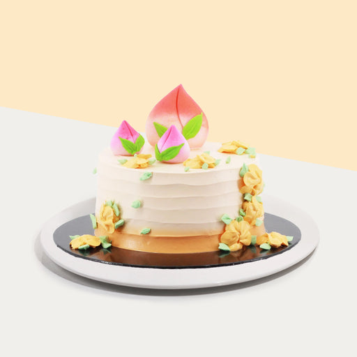 Longevity peach cake with fondant peaches on top