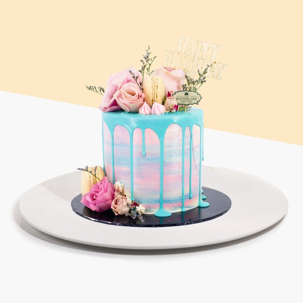 Buttercake with ombre design, along with blue chocolate drip, topped with fresh roses