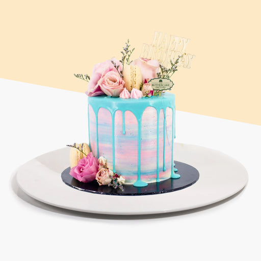 Buttercake with ombre design, along with blue chocolate drip, topped with fresh roses