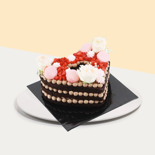 Monogram trimmed into the shape of a heart, topped with strawberries, macarons and fresh flowers