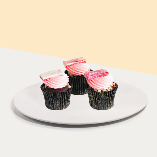 Chocolate cupcakes with white chocolate ganache, pink icing, peanut nibs and Andes mint candy