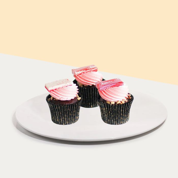 Chocolate cupcakes with white chocolate ganache, pink icing, peanut nibs and Andes mint candy