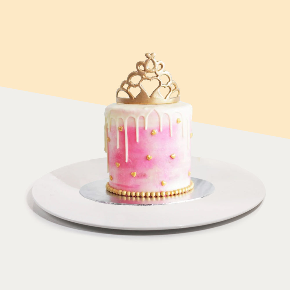 Pink buttercream princess cake with a golden crown